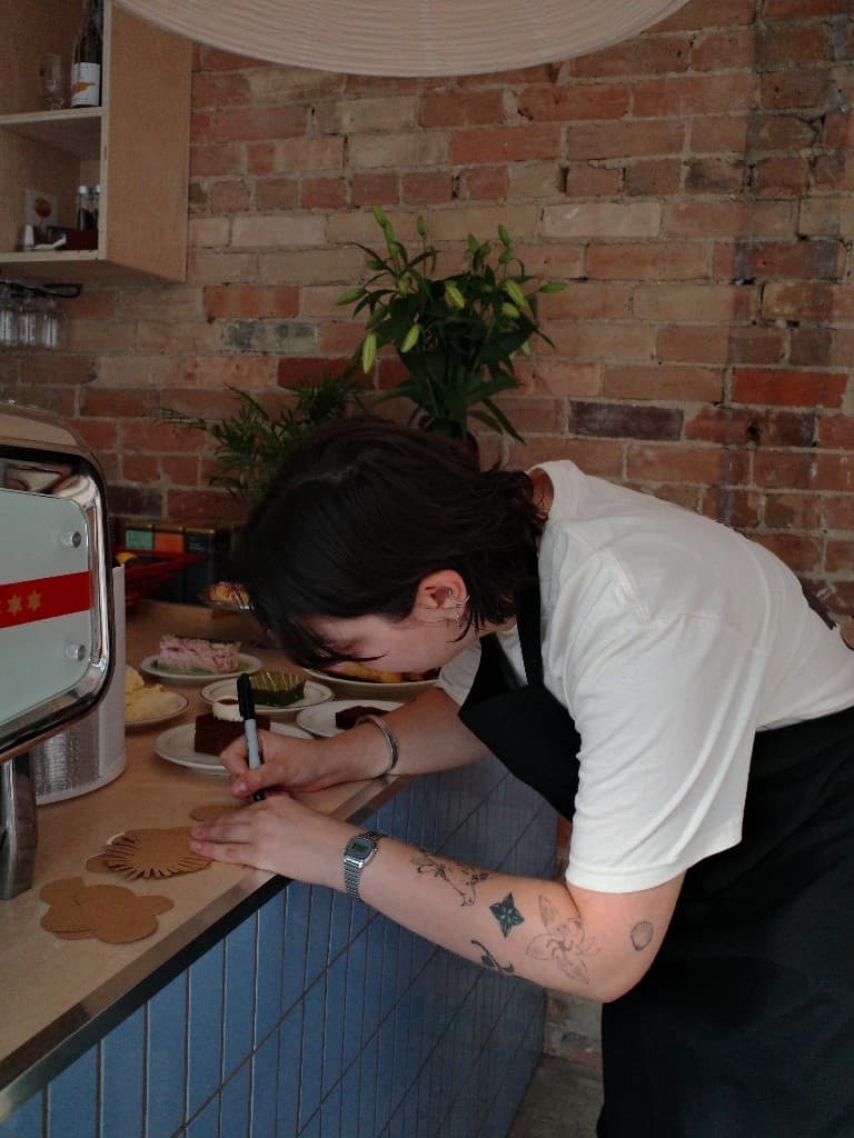Writing kraft labels for pastries at the Calmo counter